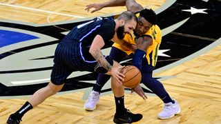 Donovan Mitchell #45 of the Utah Jazz and Evan Fournier #10 of the Orlando Magic fight for the ball during the first quarter at Amway Center on February 27, 2021 in Orlando, Florida.