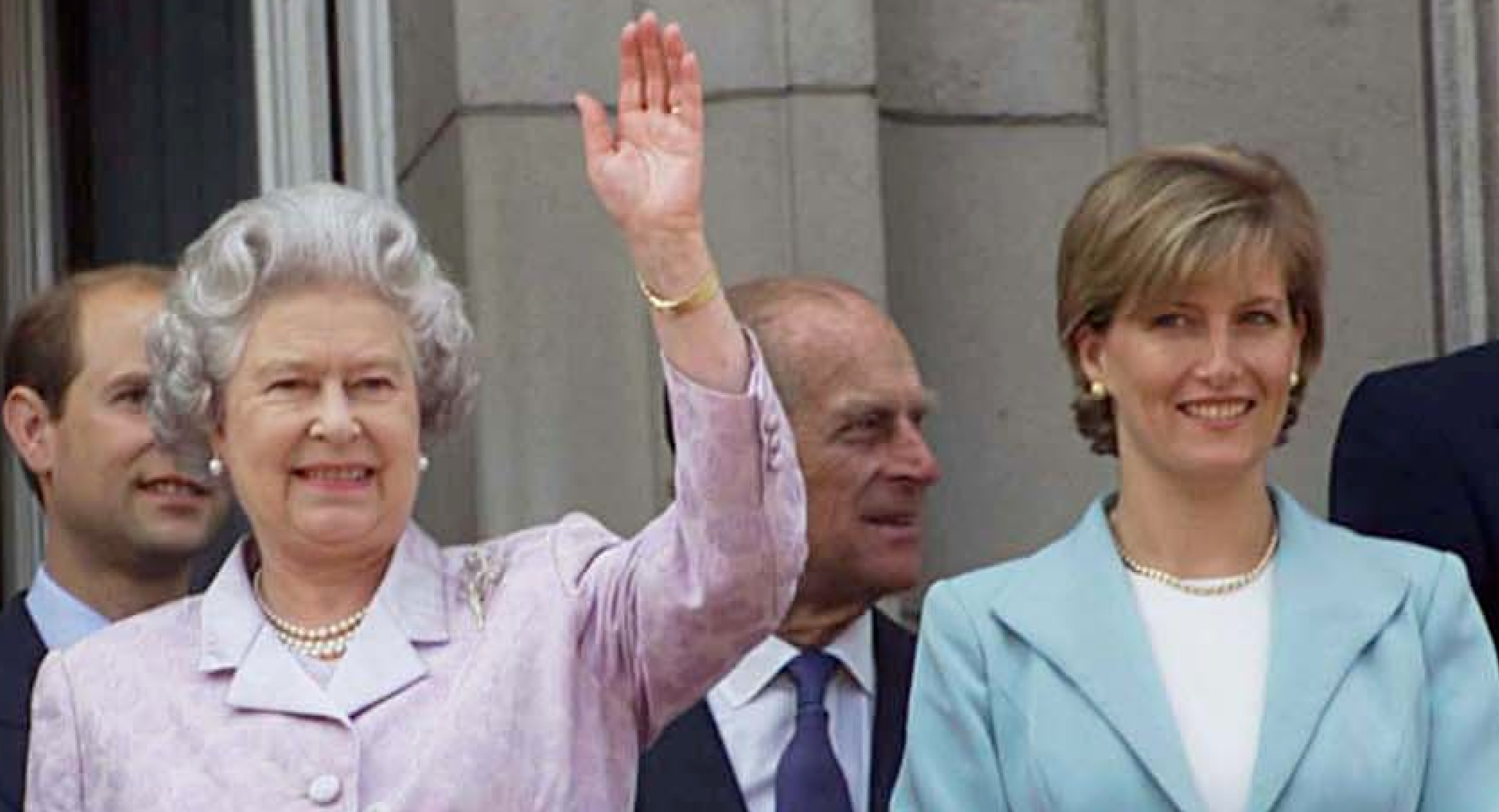 Queen Elizabeth wears a lilac and white suit and waves from the Buckingham Palace balcony while standing with Prince Edward&#039;s wife Duchess Sophie