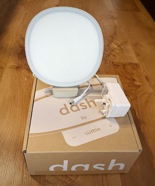 lumie dash lamp and power cable on top of branded dash box