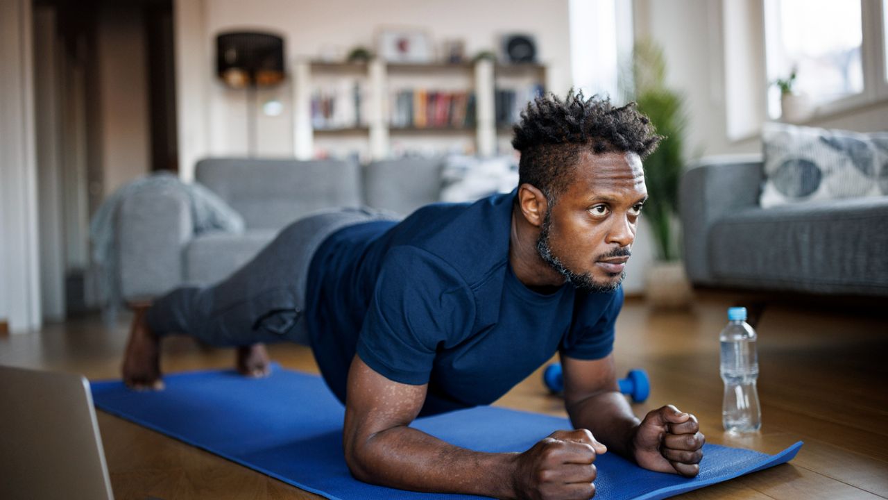 Man holding a plank at home