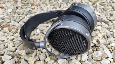 The Audeze MM-100 headphones on a background made up of stones