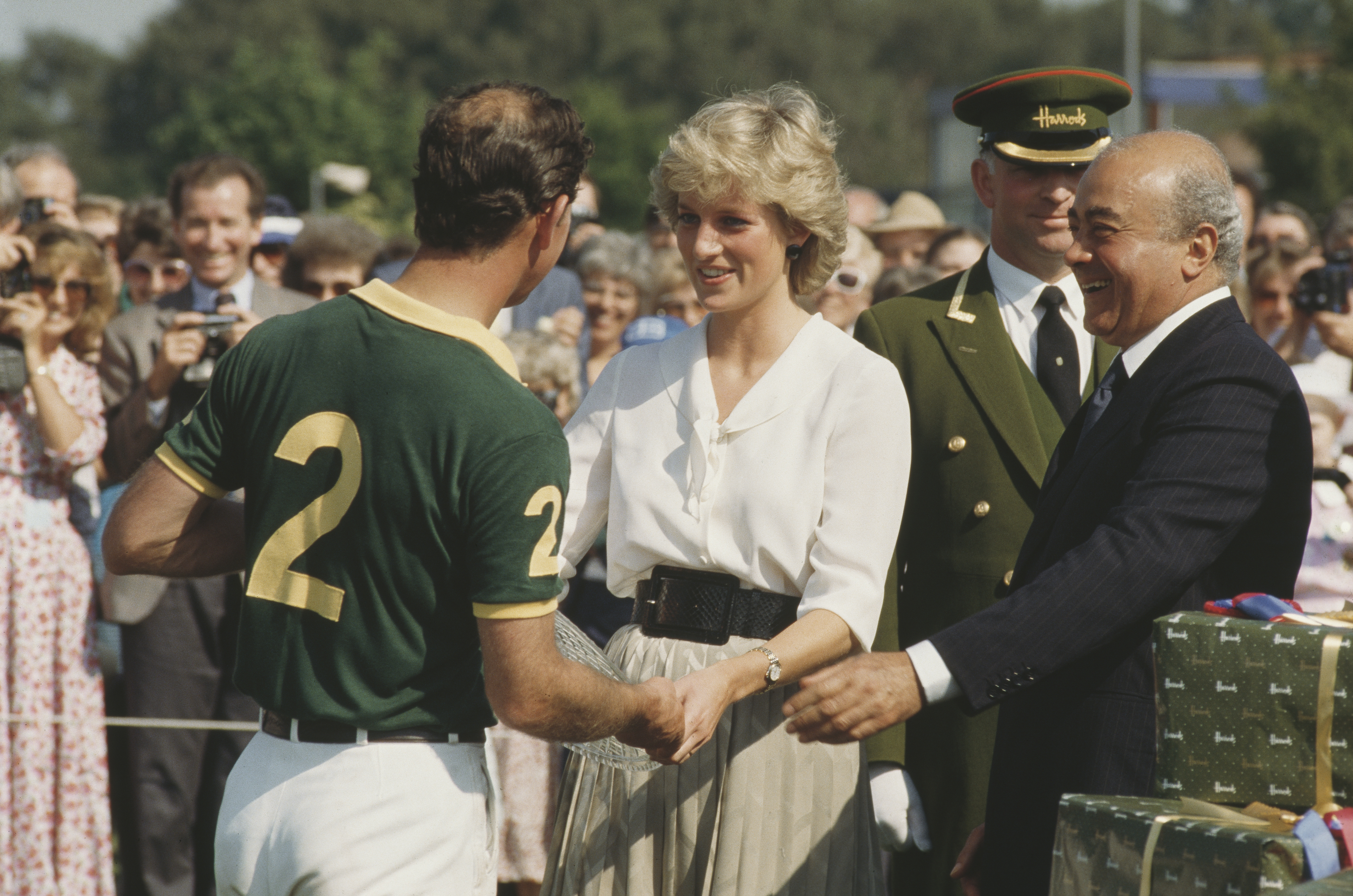 Princess Diana and Prince Charles standing on a polo field with Mohamed Al-Fayed