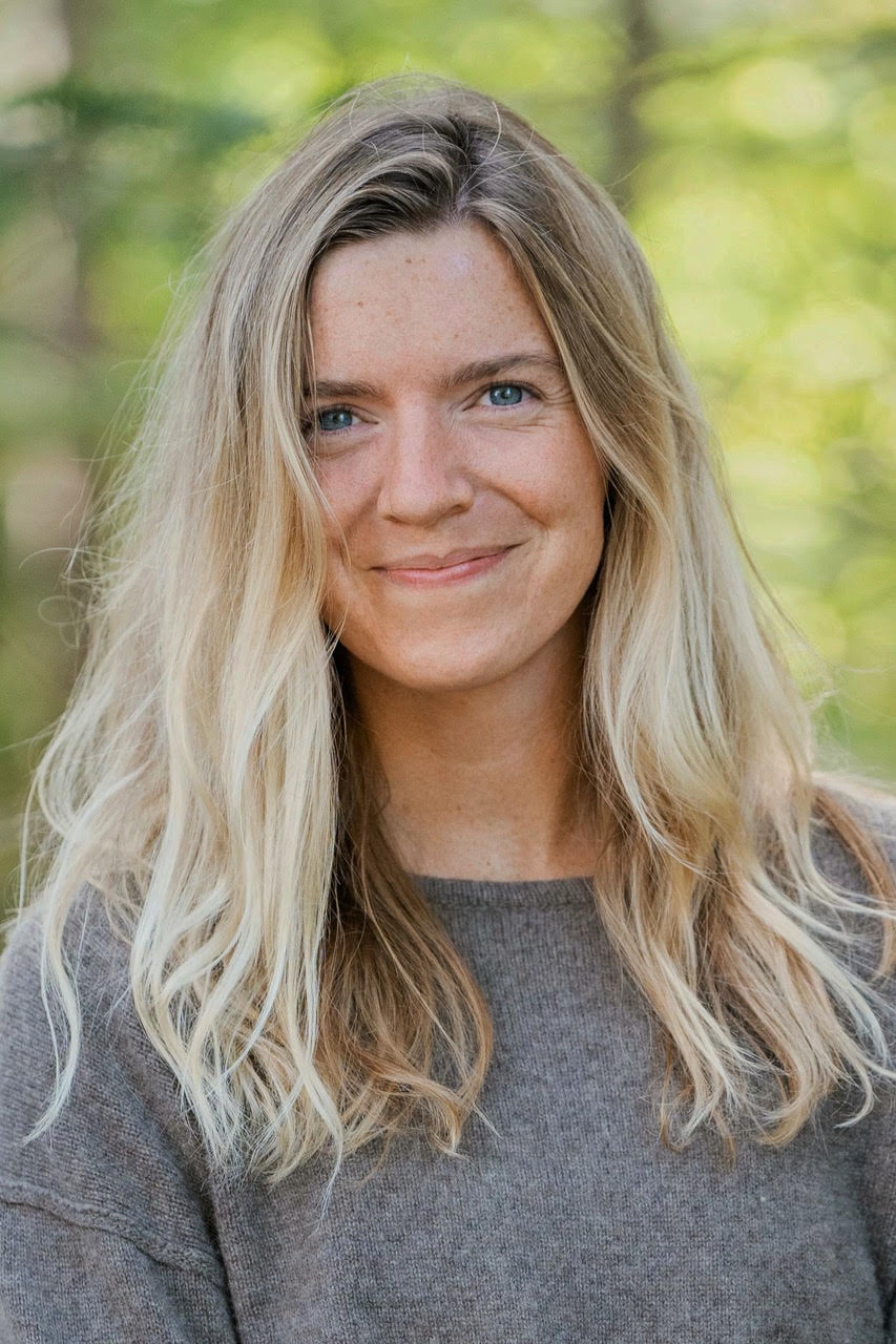 Woman headshot with blonde hair and grey sweater