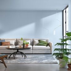 blue living room with neutral sofa and plants
