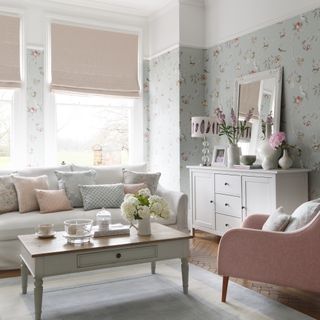 Pretty pale pink and grey living room with floral wallpaper and country-style furniture