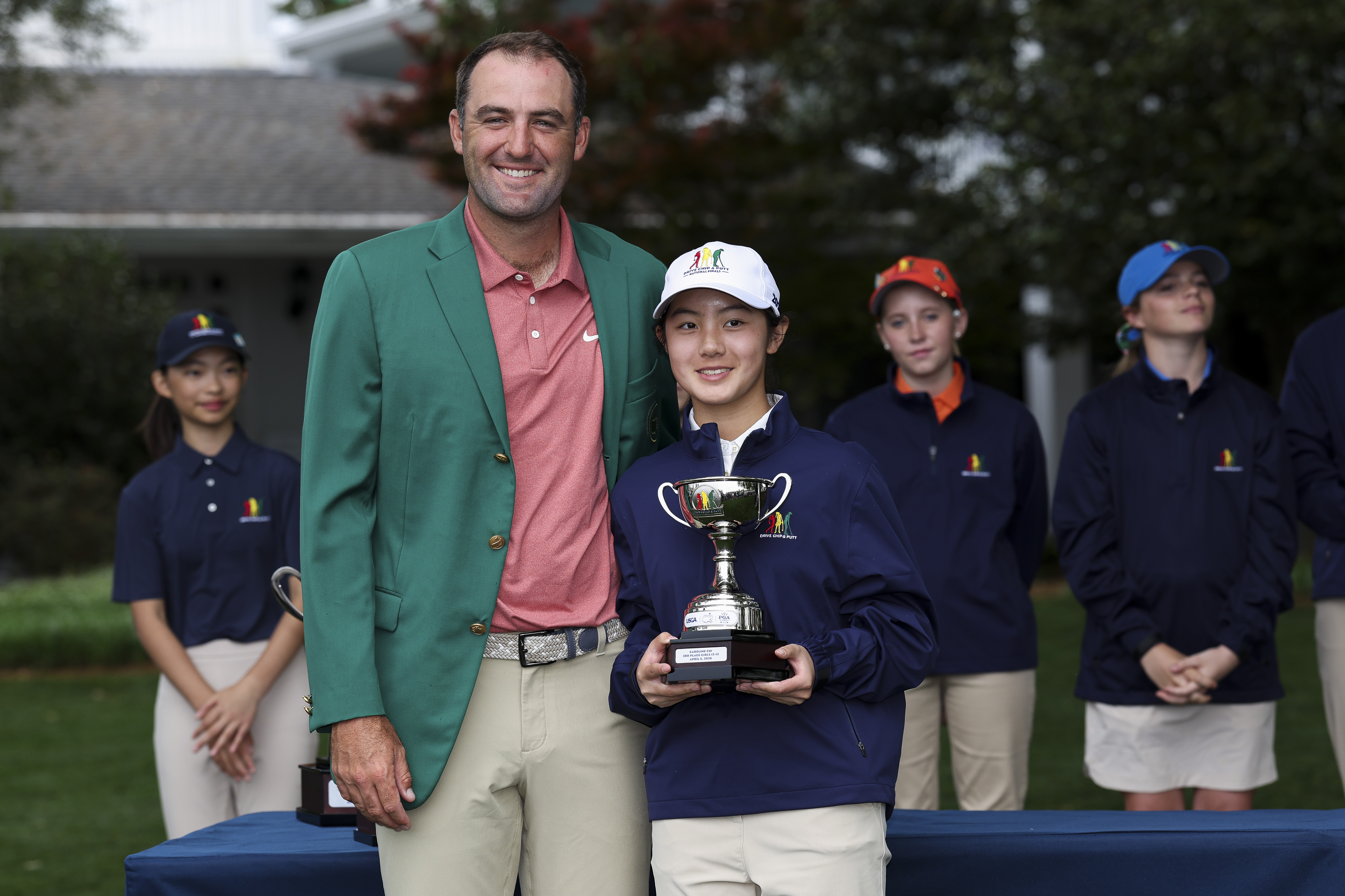 Scottie Scheffler poses with Caroline Cui of the Girls 12-13 group during the Drive, Chip and Putt Championship at Augusta National Golf Club on April 05, 2026