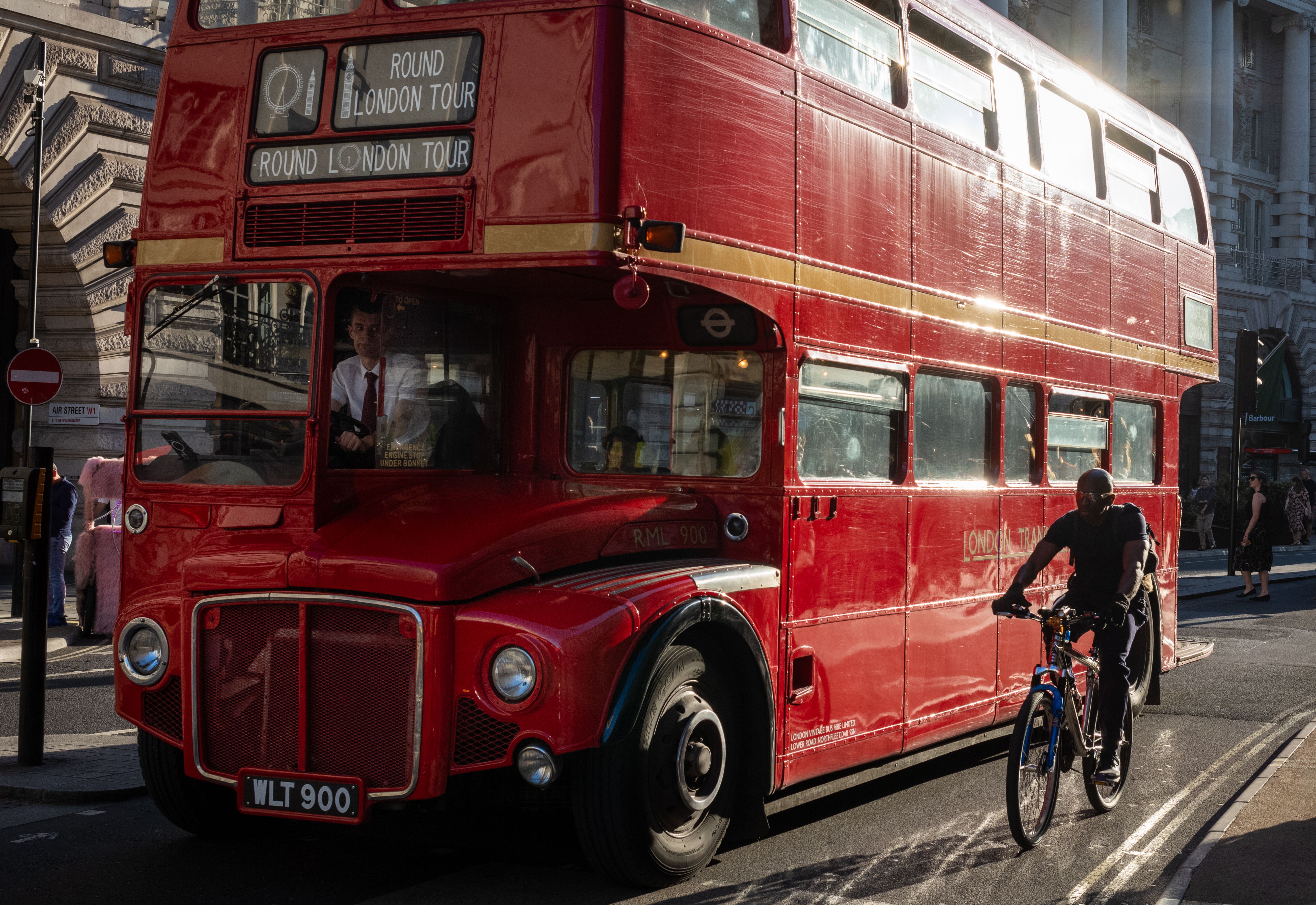 Routemaster bus and cyclist, London, UKA traditional red Route master London bus used for tours of London passes a cyclist. London, England, UK. (Photo by: Andy Soloman/UCG/Universal Images Group via Getty Images)