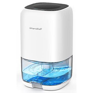 A small white plastic dehumidifier with a clear water tank at the bottom, filled with blue liquid