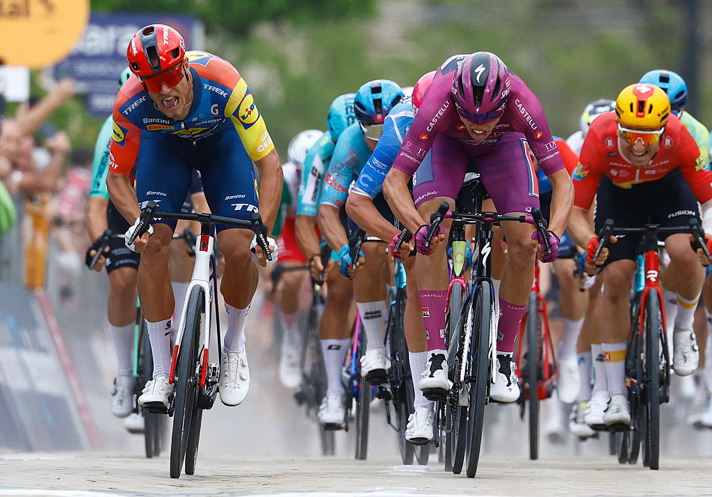 Soudal Quick-Step French rider Paul Magnier (C) wearing the points classification mauve jersey (Maglia Ciclamino) celebrates as he crosses the finish line next to Lidl - Trek Italian rider Jonathan Milan to win the 3nd stage of the Giro d'Italia 2026 - Tour of Italy cycling race between Plovdiv and Sofia, Bulgaria, on May 10, 2026. (Photo by Luca Bettini / AFP)