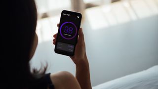 Woman looking at sleep score on mobile phone