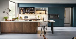 Teal blue kiitchen with white marble countertops wooden cabinets and textured surfaces to celebrate key kitchen trends 2023
