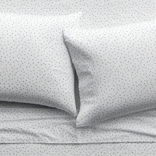 Close up on white sheets and pillowcases with black polka dots. 