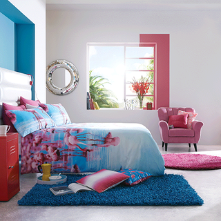 bedroom bedding with bright pink flamingo print and red side table