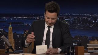 Jimmy Fallon writing on a Thank You note on The Tonight Show