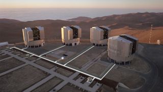 Aerial view of the observing platform on the top of Paranal mountain (from late 1999), with the four enclosures for the 8.2-m Unit Telescopes (UTs) and various installations for the VLT Interferometer (VLTI). Three 1.8-m VLTI Auxiliary Telescopes (ATs) and paths of the light beams have been superimposed on the photo. Also seen are some of the 30 'stations' where the ATs will be positioned for observations and from where the light beams from the telescopes can enter the Interferometric Tunnel below. The straight structures are supports for the rails on which the telescopes can move from one station to another. The Interferometric Laboratory (partly subterranean) is at the centre of the platform.