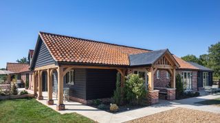 exterior of a self-build home with an oak frame porch and gravel driveway