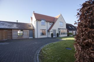 exterior of a house with modern windows, contemporary front door and a paved driveway