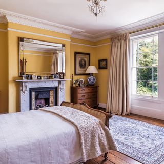 main bedroom with yellow walls and wooden flooring