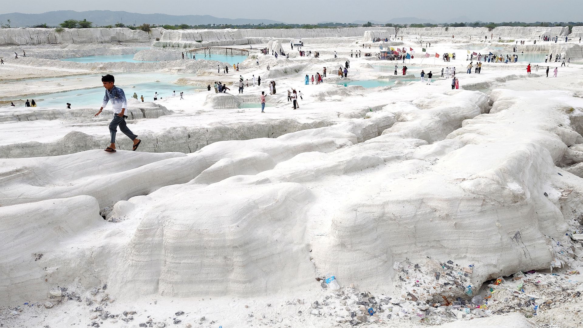 
                                A young boy walks atop mounds of snow white marble dust at a marble-waste dumping yard, which has become an unlikely tourist attraction in Kishangarh, India
                            
