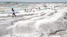 A young boy walks atop mounds of snow white marble dust at a marble-waste dumping yard, which has become an unlikely tourist attraction in Kishangarh, India