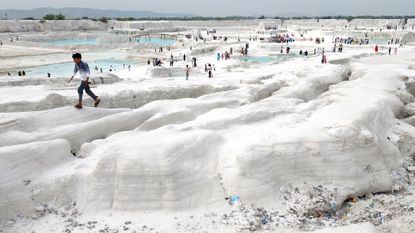 A young boy walks atop mounds of snow white marble dust at a marble-waste dumping yard, which has become an unlikely tourist attraction in Kishangarh, India