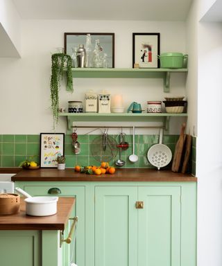 Mint green kitchen with open shelving by DeVol