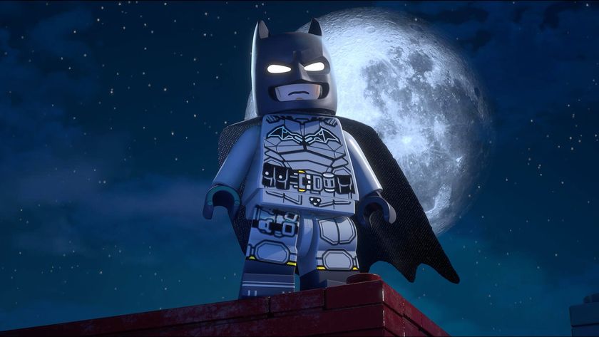 Batman stands on a rooftop in front of the moon in Lego Batman: Legacy of the Dark Knight