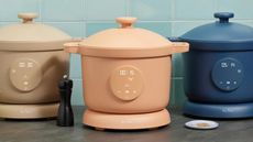 Three Our Place Dream Cookers in beige, terracotta, and blue