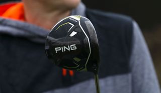 A close up of the Ping G430 Max Driver on a grey background