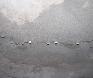 close up of ceiling with damp patches and droplets of condensation