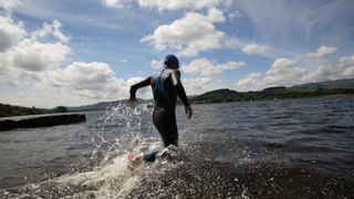 man running into a lake