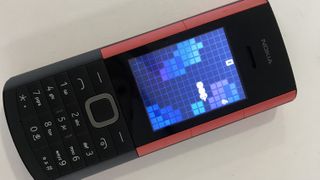 Nokia 5710 XpressAudio with Snake Xenia playing, on beige background