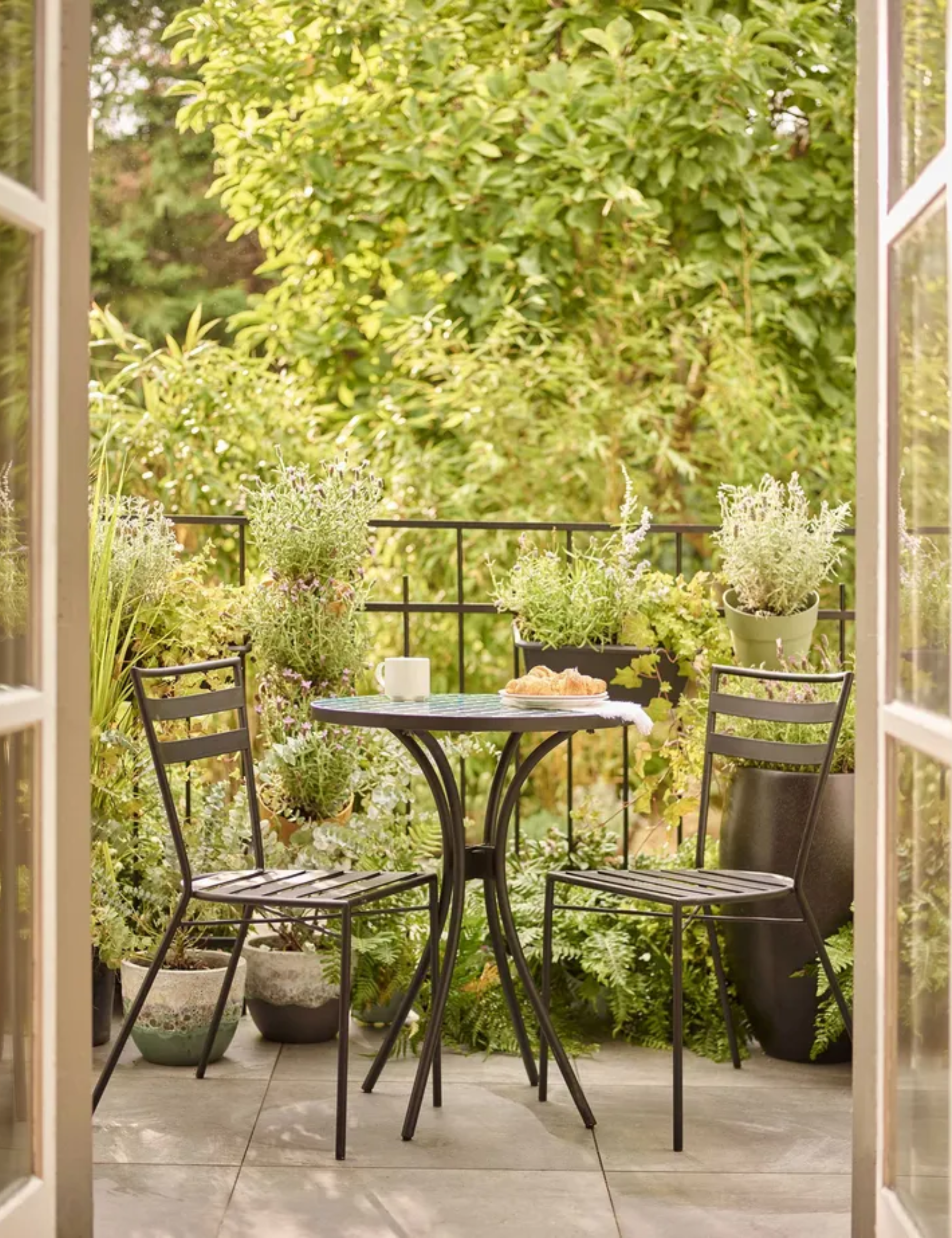 Dobbies balcony garden with bistro set and potted plants