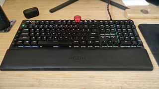 An AOC AGON AGK700 keyboard on a wooden desk