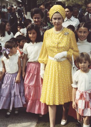 Queen Elizabeth II with a group of local children during her state visit to Mexico, 1975.