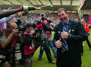 Kevin Campbell pours champagne over Bryan Robson of WBA after securing premiership status at the end of the Barclays Premiership match between West Bromwich Albion and Portsmouth at The Hawthorns on May 15, 2005 in Birmingham, England.