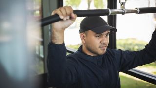 Man performs lat pull-down