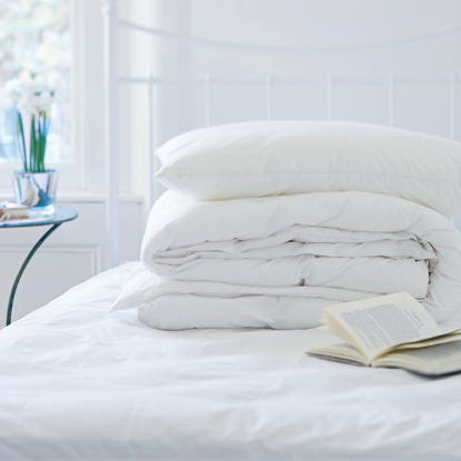 Duvet and pillows pile on bed.