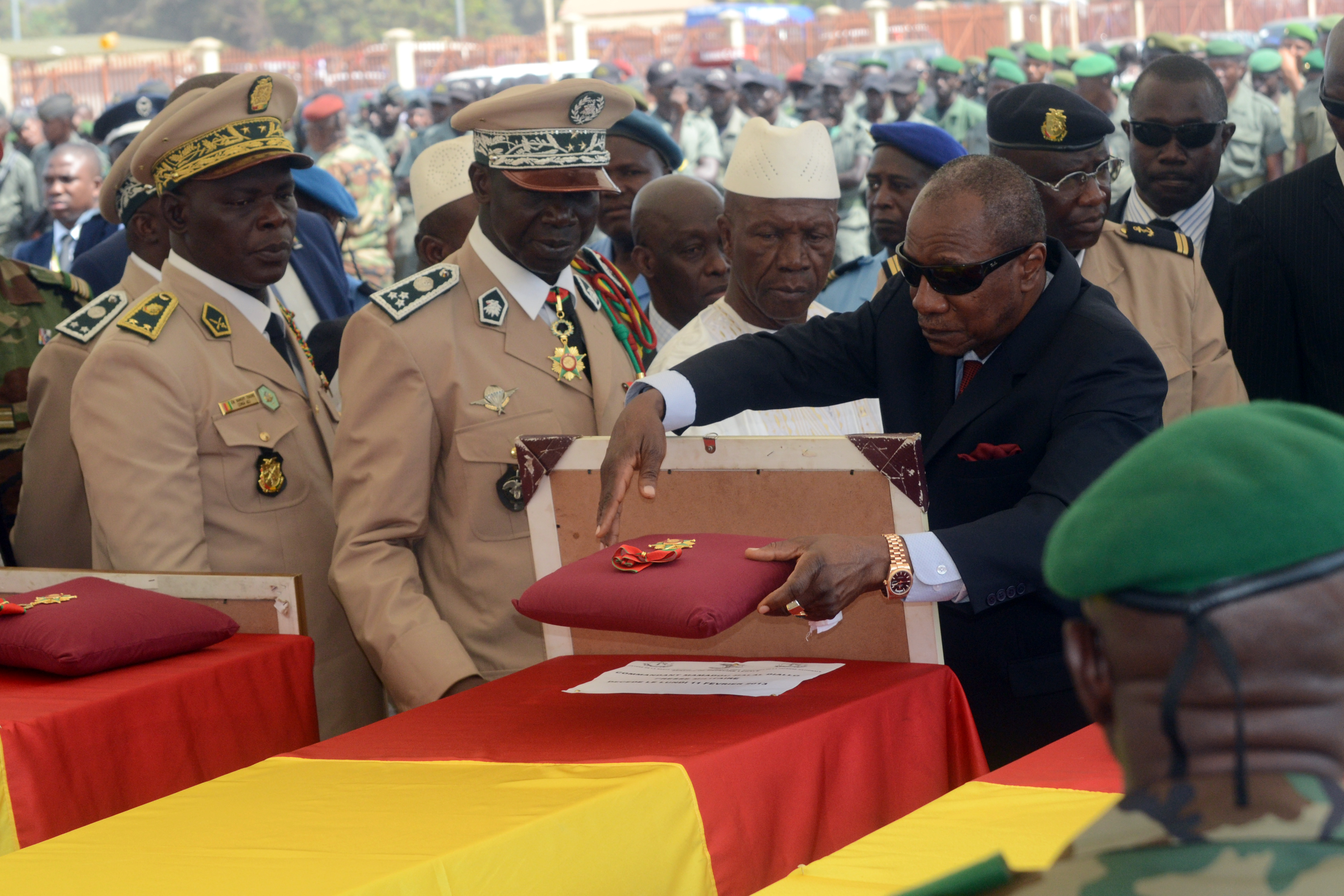 Aboubacar Sidiki (Titi) Camara (second left) and Guinea's Prime Minister Mohamed Said Fofana (centre) decorate the coffins of the victims of a plane carrying a military delegation from Guinea that crashed in the Liberian town of Charlesville, killing the army chief of staff and 10 other people, during a ceremony in Conakry in February 2013.