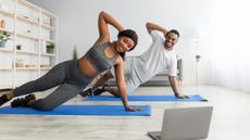couple workout together in a side plank position