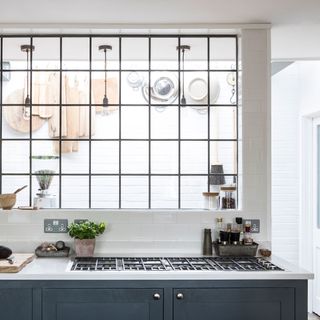 white kitchen with crittall internal window and hanging chopping boards