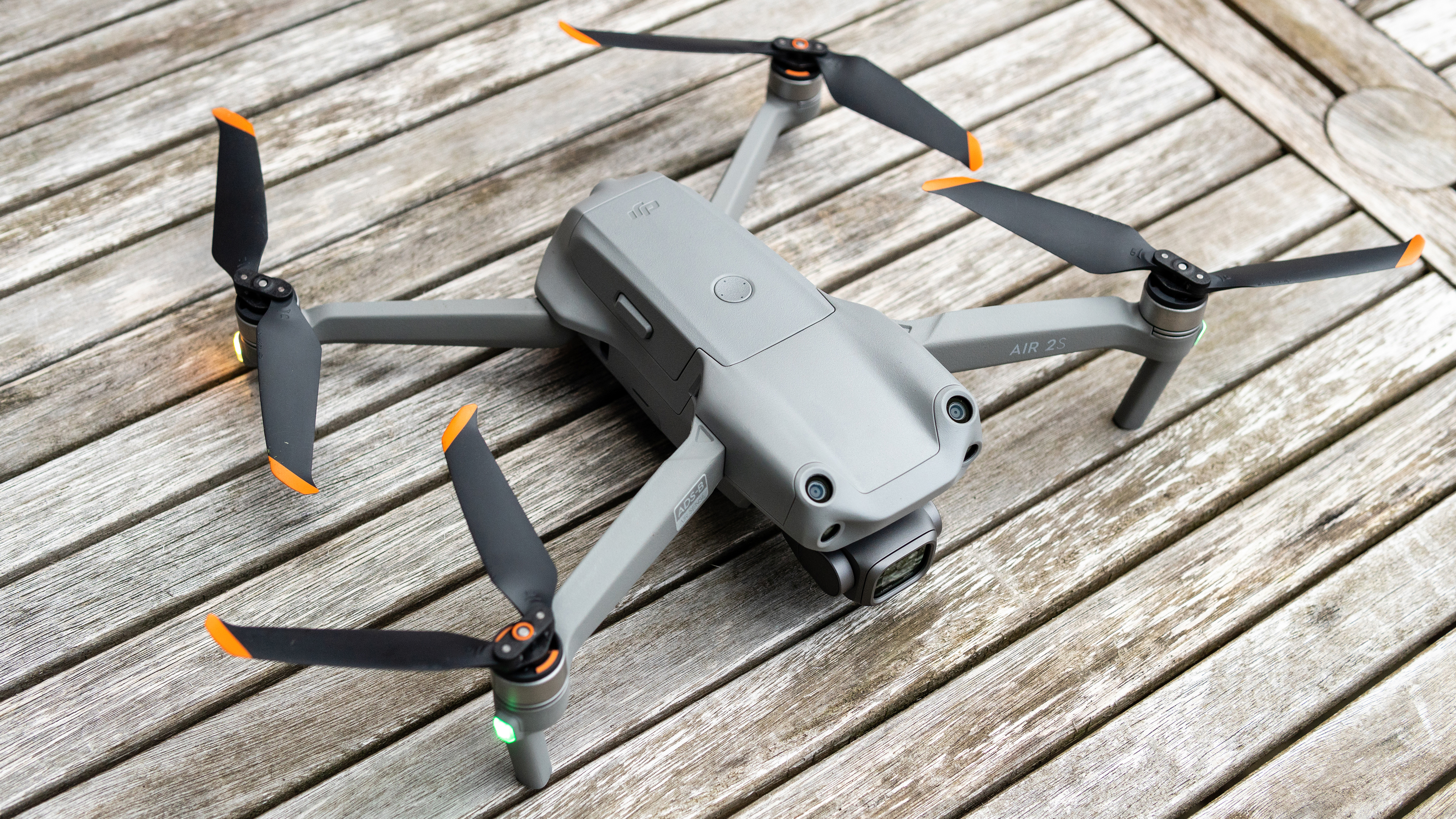 The DJI Air 2S drone on a table with its arms unfolded, preparing for take-off