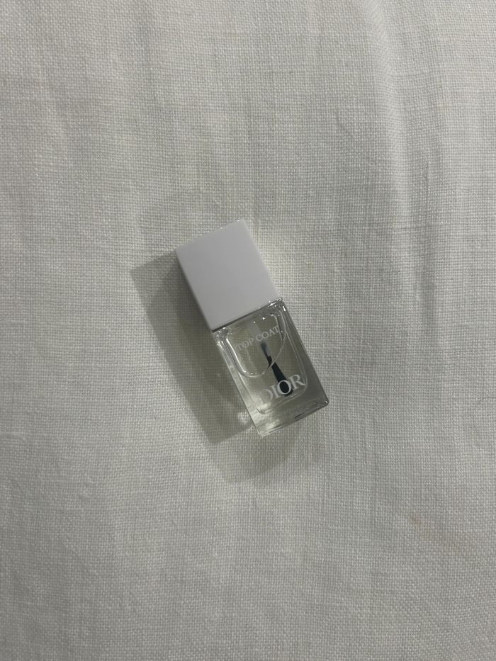 The Dior Top Coat on a white linen background