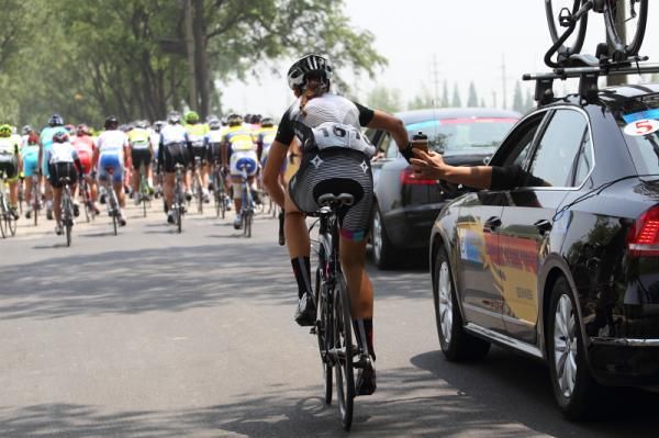 Ally Stacher (Specialized - lululemon) takes a bidon from Ronny Lauke in the team car