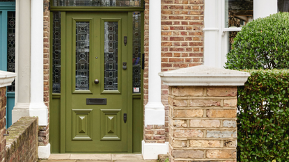 Green period front door with stained glass window design