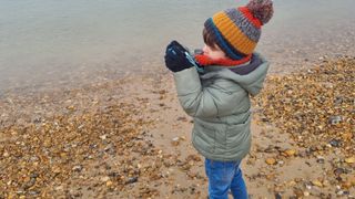 Image of a toddler on a pebble beach
