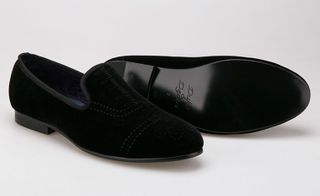 A pair of black suede men's slip-on shoes.