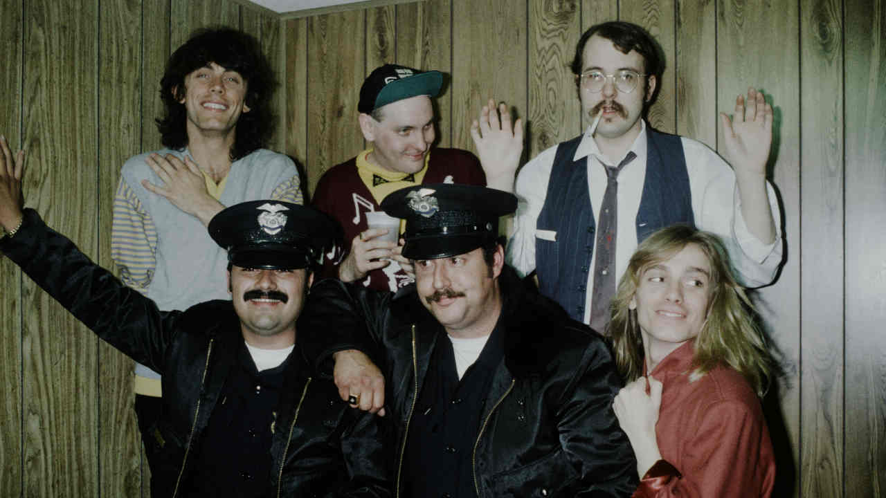 Cheap Trick posing for a photograph with two US police officers in the late 1970s