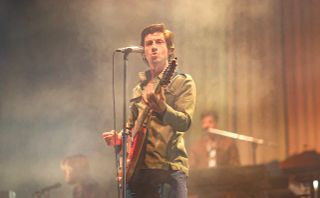 Arctic Monkey frontman Alex Turner performing on stage.