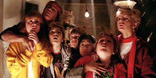 The Goonies cast looking up from their hiding place with concern